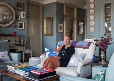 sheila bridges sitting in a living room with throw pillows featuring her harlem toile de jouy