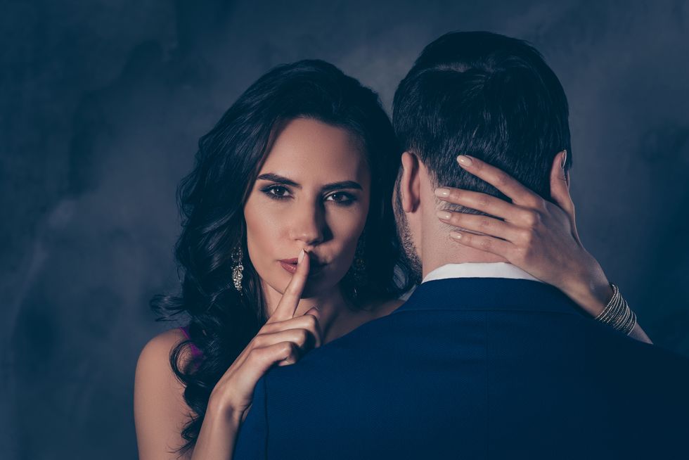 shh portrait of tempting brunette lady showing silence sign with forefinger touching secret mysterious gentlemen with rear view, lovely mr and mrs isolated on grey background