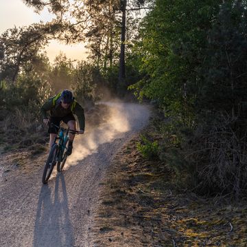 mountainbiker in de schemering met stofwolk
