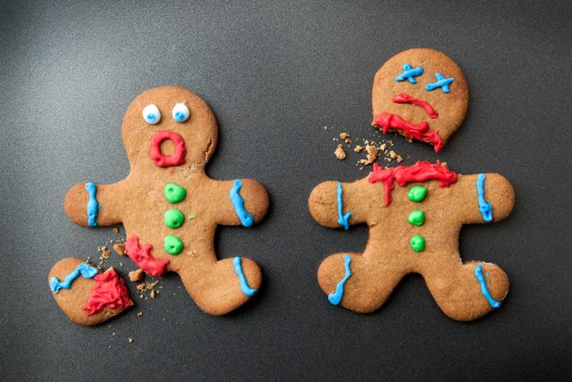 A shocked gingerbread man with broken leg next to a decapitated gingerbread man