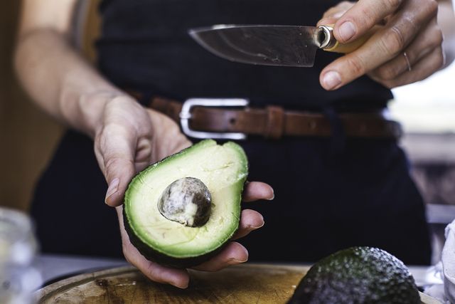 Vrouw halveert avocado