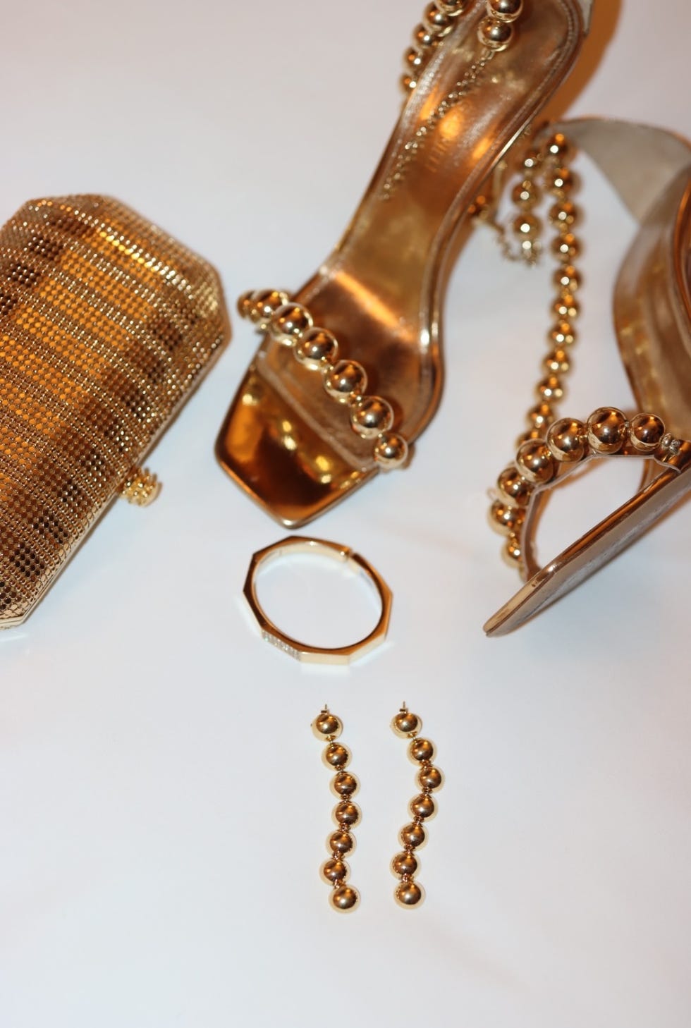 fashion accessories including shoes a clutch a bracelet and earrings