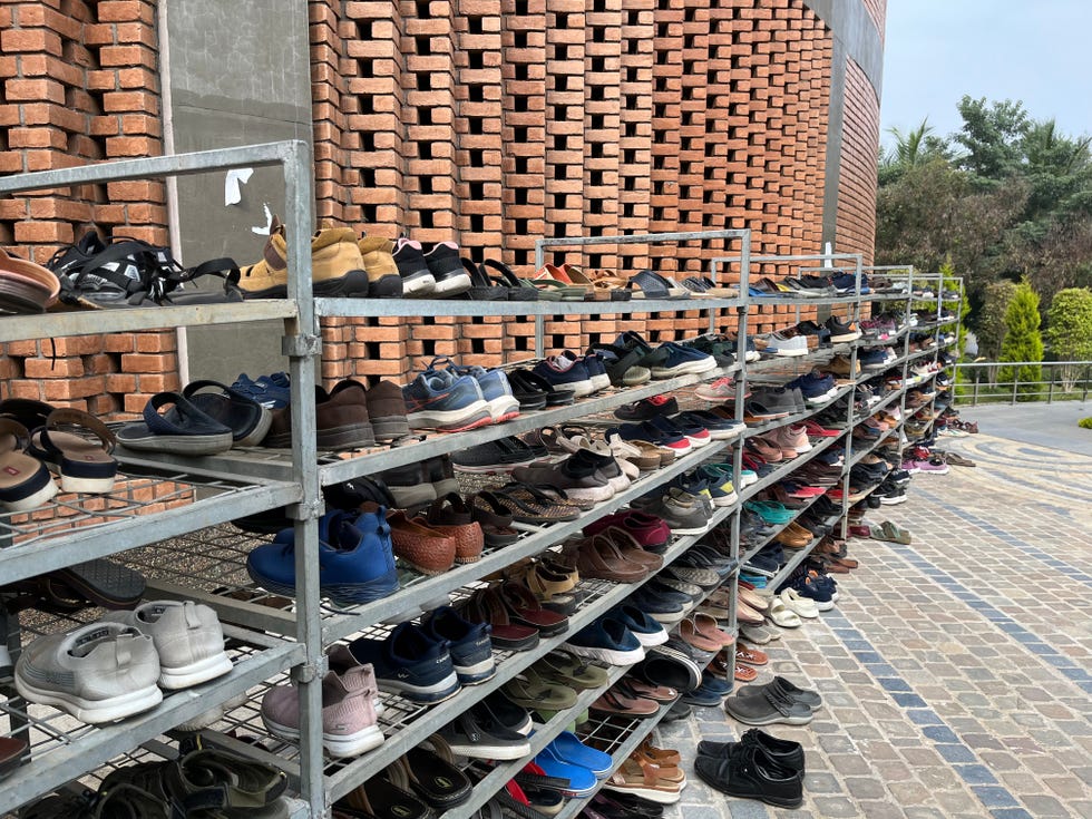 a rack of shoes outside the kanha shanti vanam meditation hall