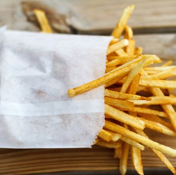 shoestring french fries in white paper bag on picnic table