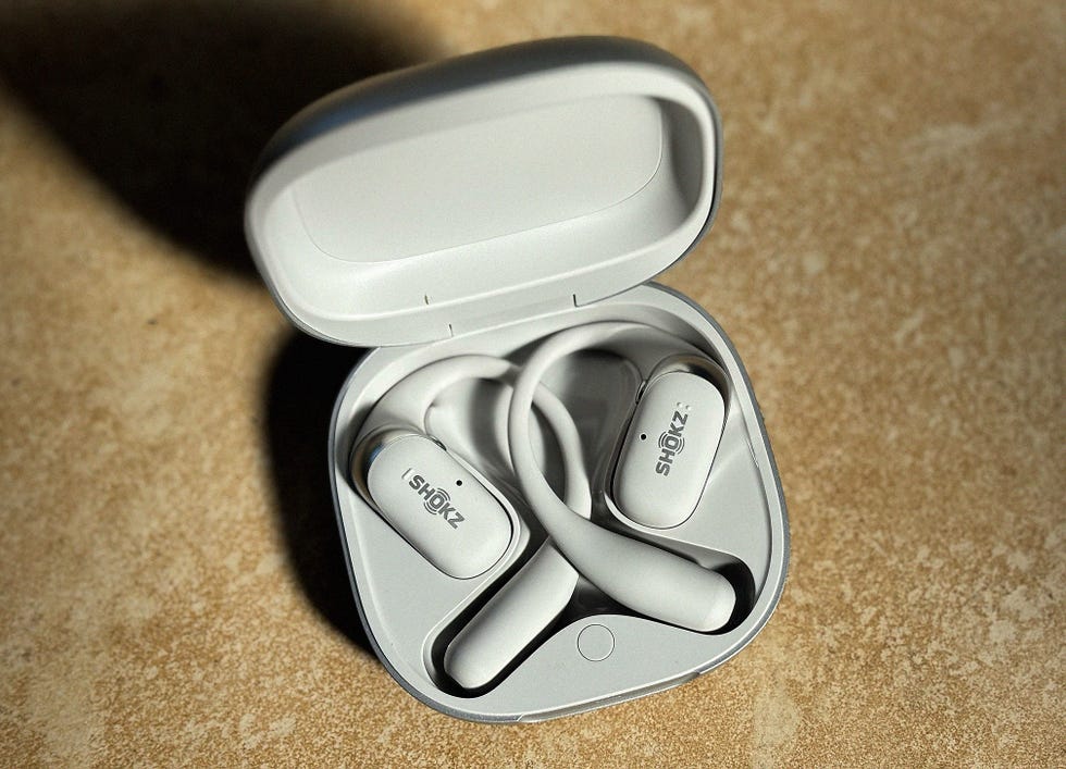 a pair of grey running earbuds in a charging case
