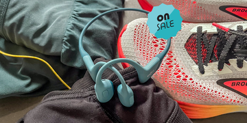 shokz openrun headphones on a pile of other running gear