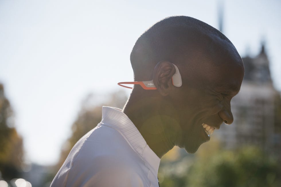 eliud kipchoge smiling while wearing headphones