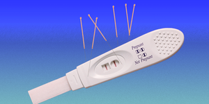 a pregnancy test with acupuncture needles sticking out of it
