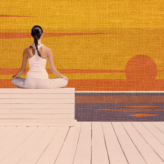 woman meditating in front of a sunset