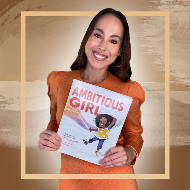 meena harris poses with a copy of 'ambitious girl'