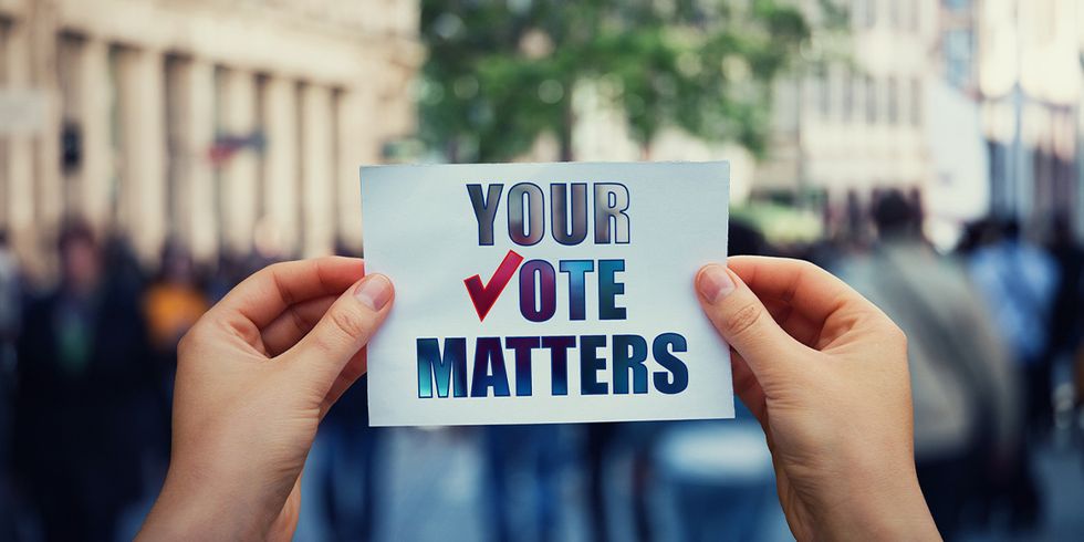 hands holding up a sign that says "your vote matters"