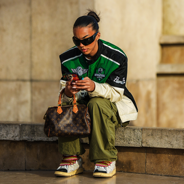 woman sitting on the curb and looking at her phone