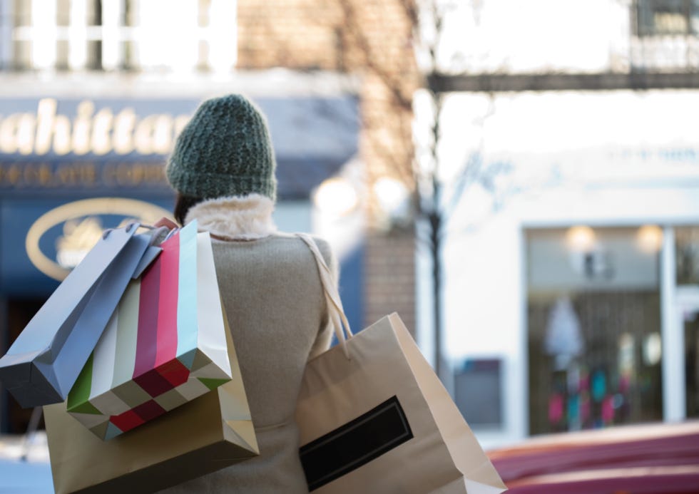 mujer, con gorro de lana, carga con bolsas de compra