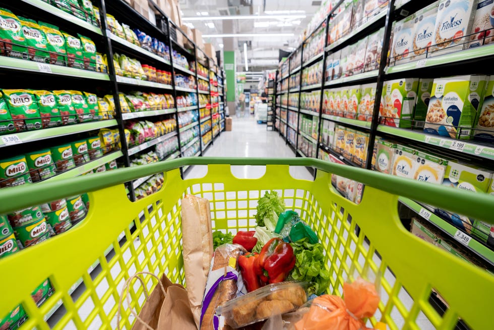 shopping cart down the supermarket aisle filled with groceries