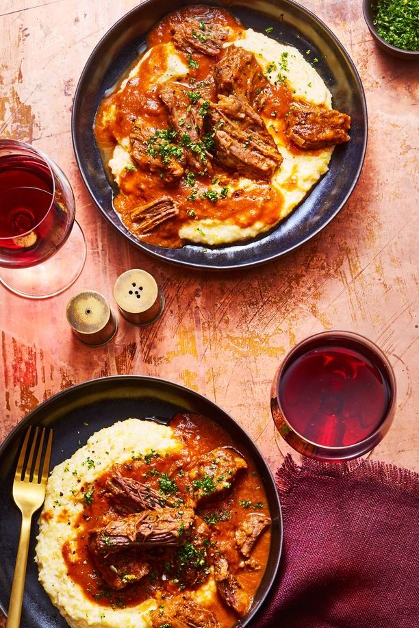 short ribs with creamy polenta on a plate served with wine