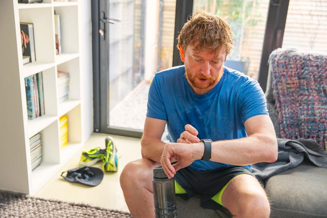 man checks watch after running workout