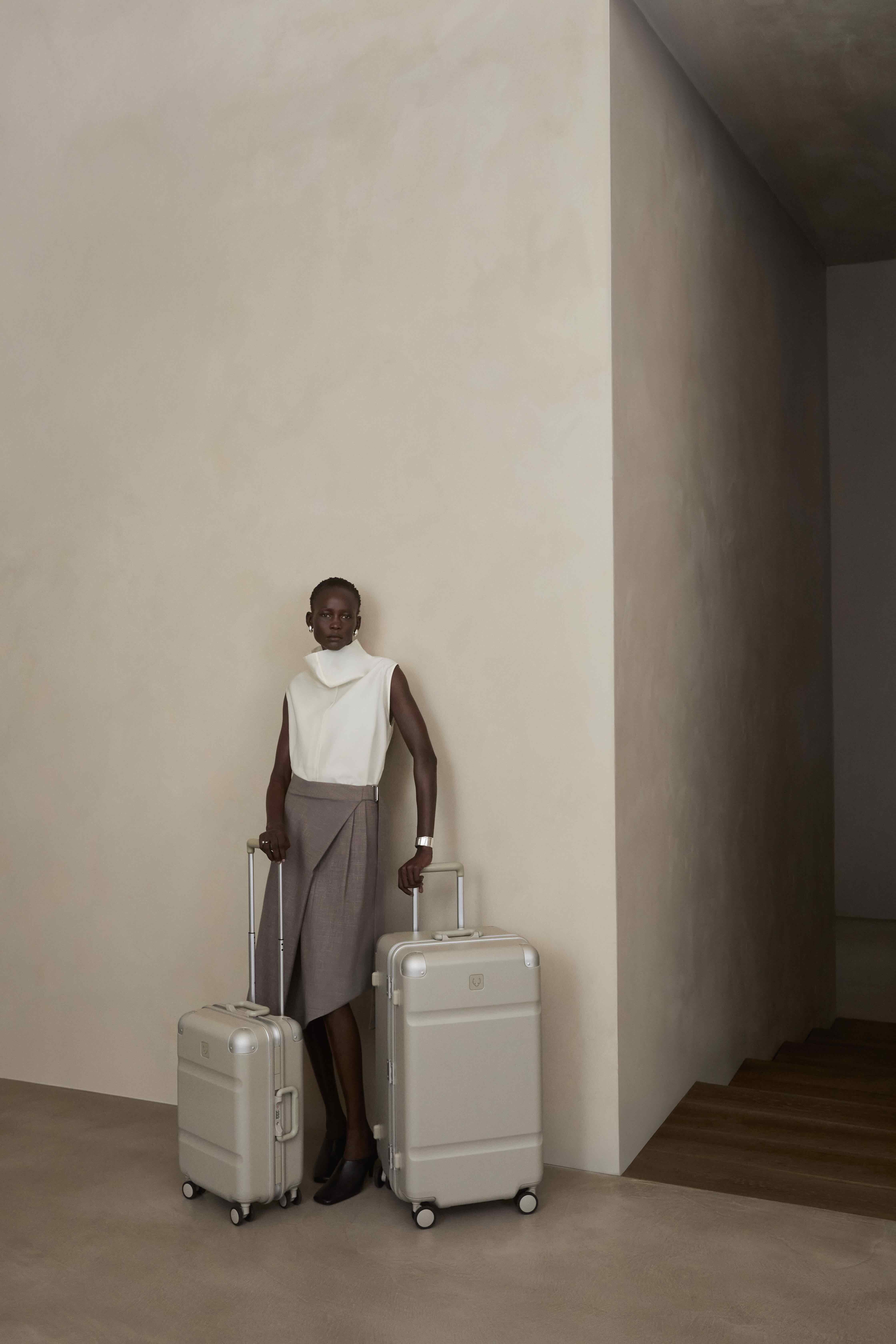 a woman standing with two suitcases