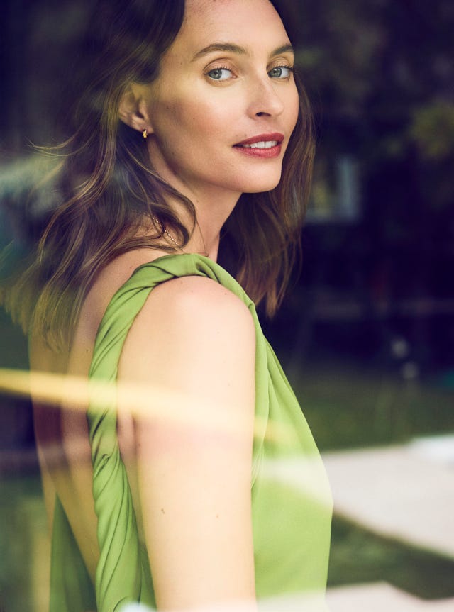 a woman wearing a green dress viewed from the side