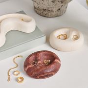 three vessels designed by claude home resting on a tabletop and filled with jewelry from the mejuri claude home collaboration 2022