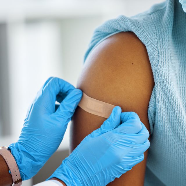 shot of a doctor applying a plaster to her patients arm