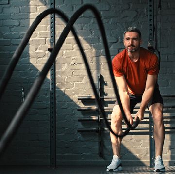 shot of a handsome mature man standing and using battle ropes in the gym during his workout