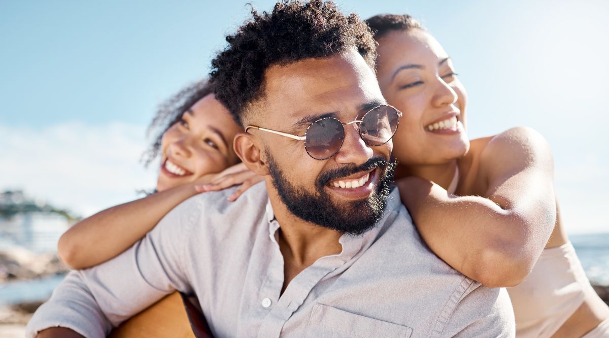 shot of a man at the beach with his two female friends