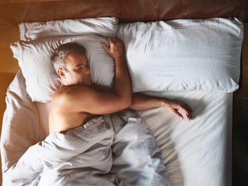 shot of a mature man sleeping shirtless in his bed