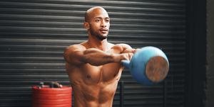 shot of a muscular young man exercising with a kettlebell in a gym