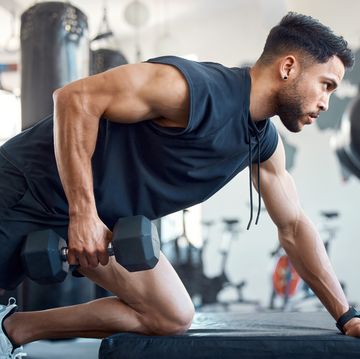 shot of a sporty young man exercising with a dumbbell in a gym