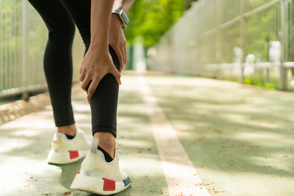 shot of a woman massaging an injury in her leg