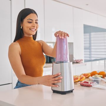 shot of a woman preparing a smoothie in the kitchen at home