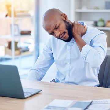 shot of a young businessman suffering from back pain in a modern office at work