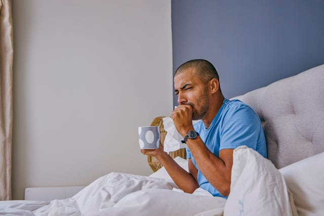 shot of a young man suffering from a cold at home