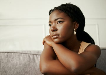 shot of a young woman looking depressed at home