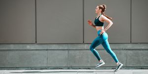 shot of a young woman running touch-strap outside