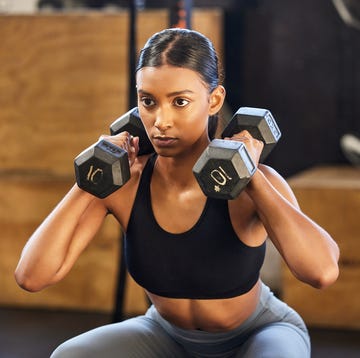 shot of a young woman working out with weights in a gym