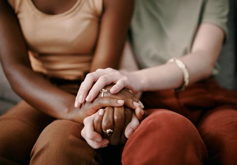 Shot of two friends holding hands and supporting each other