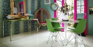 Dining room with teal walls, fuchsia door frame and emerald dining chairs