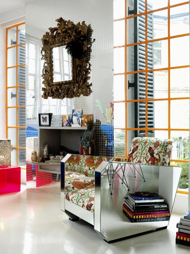 Matthew Williamson's living room with mirrored walls, mirrored armchair and orange framed windows