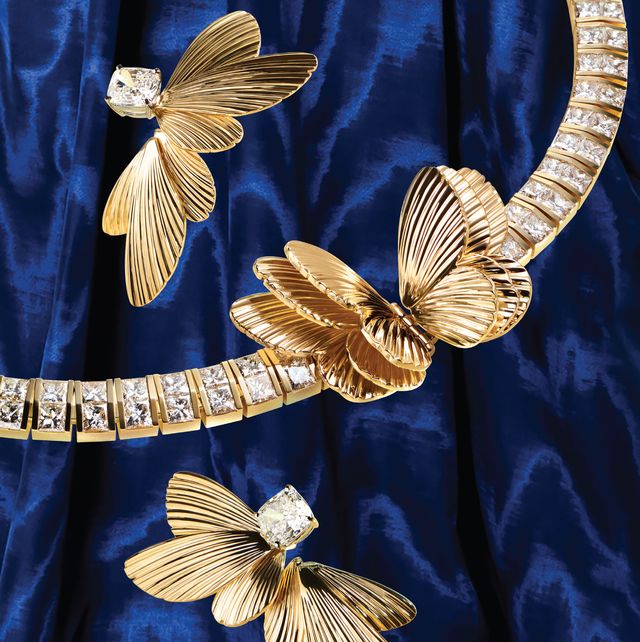 gold earrings and collar against blue velvet background