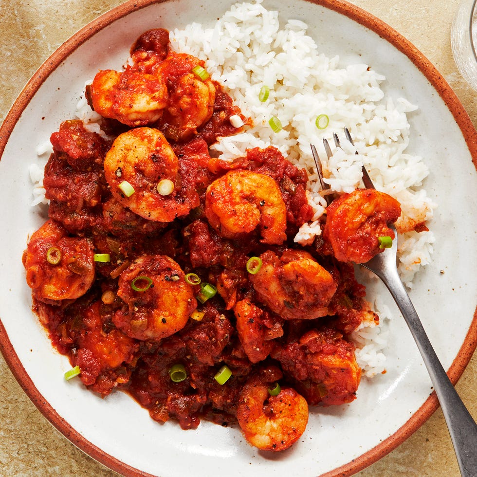 shrimp in a tomato based stew topped with chives and served with rice