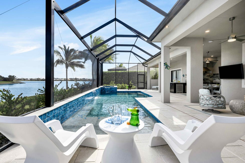 caged pool with various outdoor entertaining zones