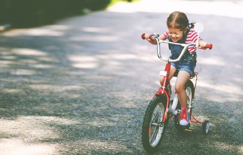 young girl riding bike happily