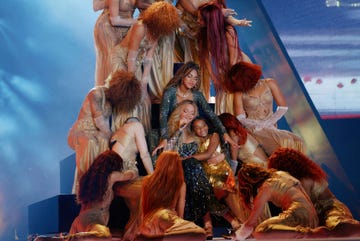 performance scene with dancers and a central figure in a dramatic pose