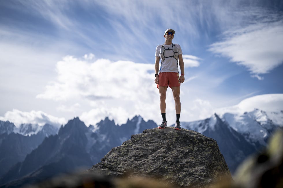 tom evans standing on a rock with mountains in the background