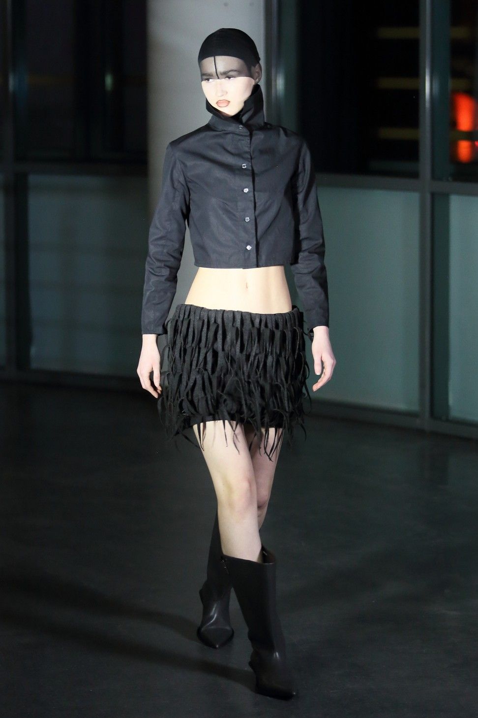 a person wearing a black jacket and black skirt