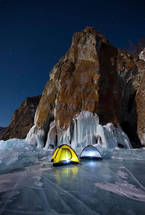 Vanuit twee tenten schijnt bij nacht licht op het Baikalmeer