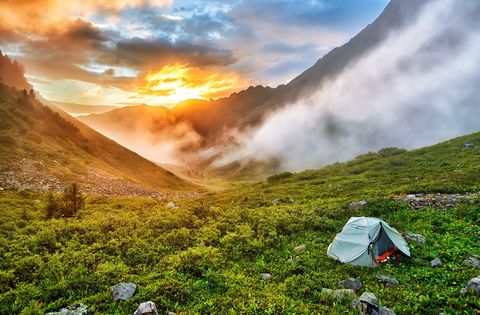 De zon komt op boven een tent in de bergen in Boerjati in Siberi