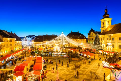 sibiu, romania   20 december 2014 night image with tourists at christmas market in great market of medieval sibiu, transylvania landmark