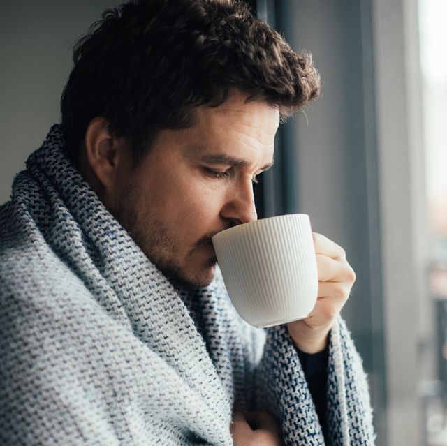 https://hips.hearstapps.com/hmg-prod/images/sick-man-trying-to-warm-up-with-blanket-and-a-cup-royalty-free-image-1702489786.jpg?crop=0.668xw:1.00xh;0.107xw,0&resize=640:*